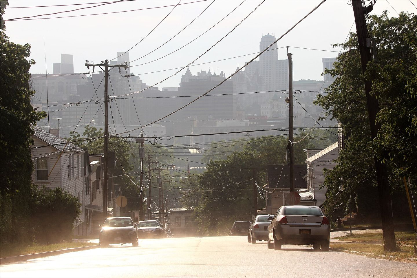 A Rensselaer street sloping down toward the Albany skyline across the Hudson