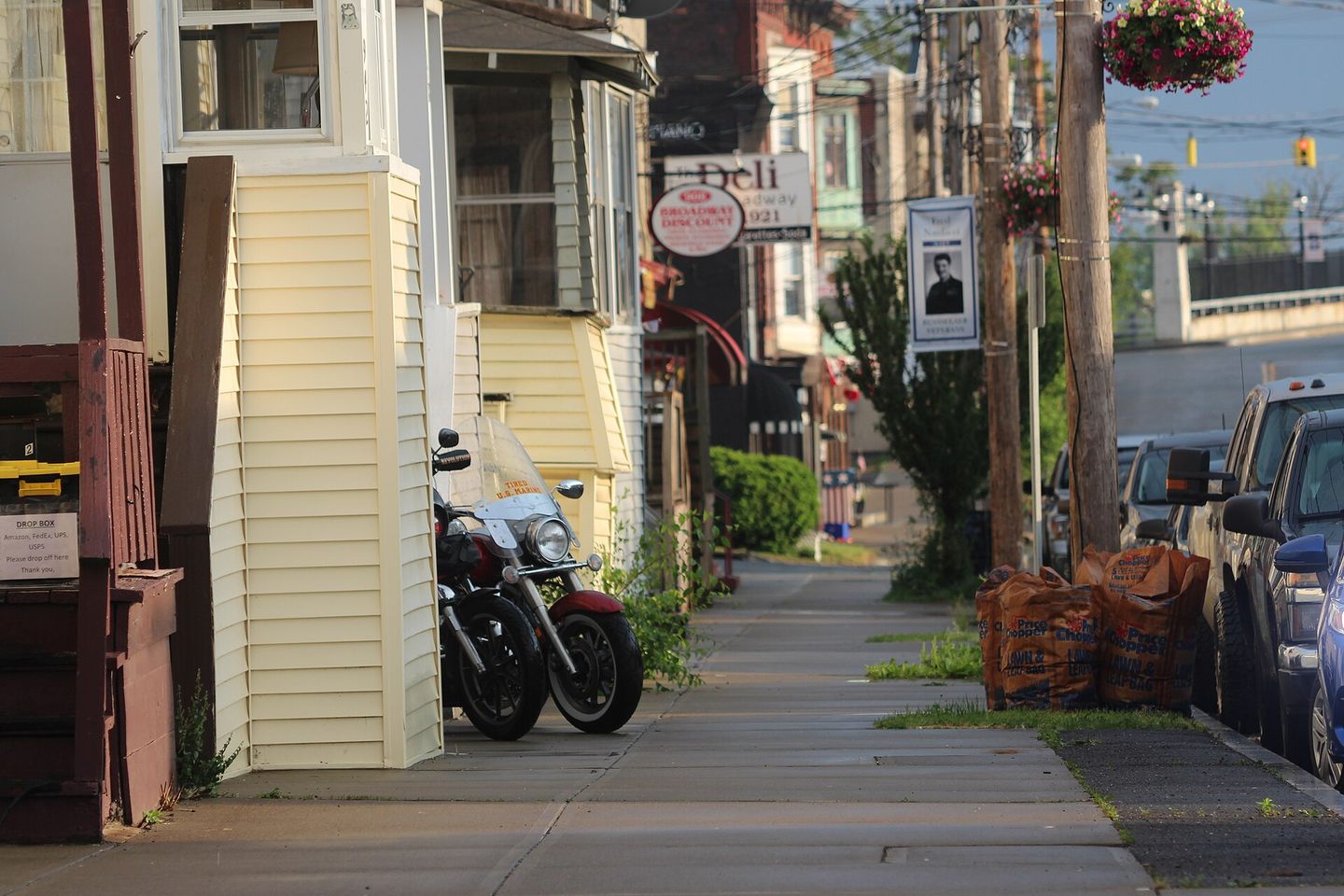 Sidewalk along Broadway in Rensselaer, New York, with homes and storefronts