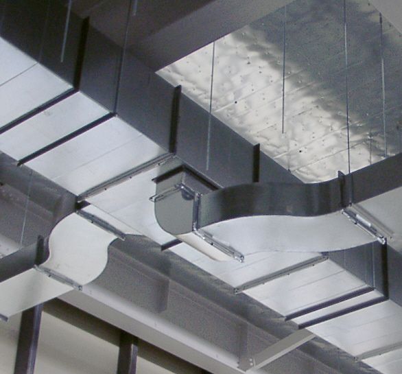 Galvanized supply ductwork with a branch takeoff hung from a ceiling